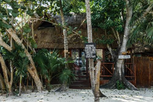 a sign in front of a building with trees at Eco Bañitas Tulum in Tulum