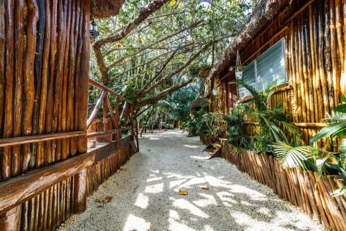 a walkway next to a building with trees and plants at Eco Bañitas Tulum in Tulum