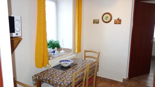 a small table with a bowl on it next to a window at Guest House Melusine in Loučná pod Klínovcem