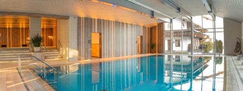 a large swimming pool in a building at MONDI Resort und Chalet Oberstaufen in Oberstaufen