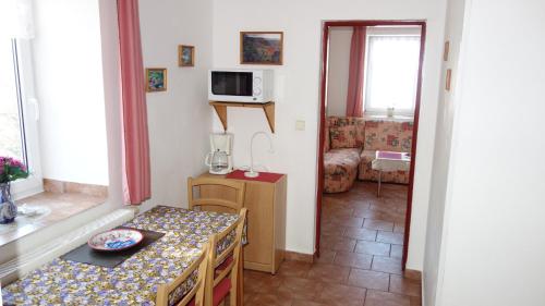 a small room with a table and a microwave at Guest House Melusine in Loučná pod Klínovcem