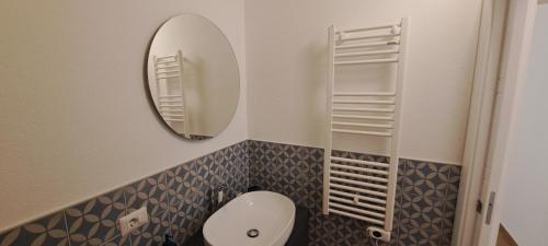 a bathroom with a white toilet and a mirror at Urban Charme Palau in Palau