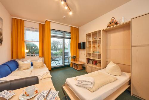 a small room with two beds and a table at Strandburg-Küken in Fehmarn