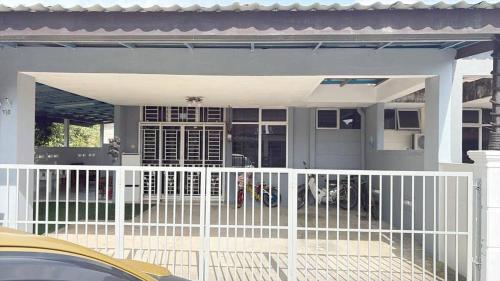 a white fence in front of a house at iLham Homestay in Kangar