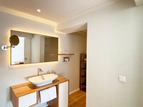 une salle de bain avec un lavabo et un miroir dans l'établissement Pier 16 im Pierspeicher, à Kappeln