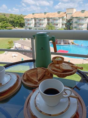 a table with a cup of coffee and cookies at Aldeia das águas Park Resort - Flat D308 Village das Águas in Barra do Piraí