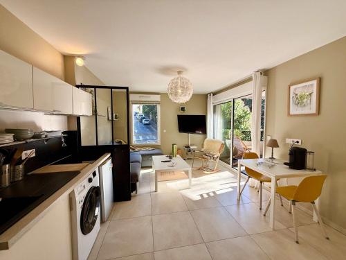 une cuisine et un salon avec une table et des chaises dans l'établissement A011-Superbe Studio avec Terrasse Sauna Jacuzzi, à Cannes