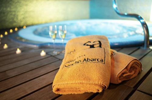 a towel sitting on a table next to a bath tub at Hotel Sancho Abarca Petit SPA in Huesca