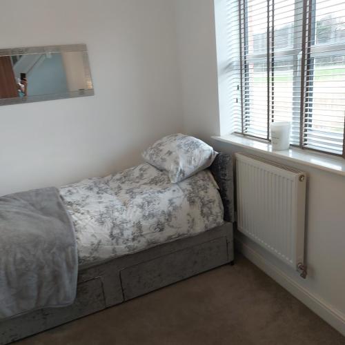 a bedroom with a bed with a pillow on it at Executive, 3-storey town house in Runcorn