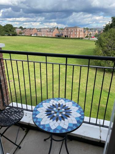 a blue table and chairs on a balcony with a field at Executive, 3-storey town house in Runcorn
