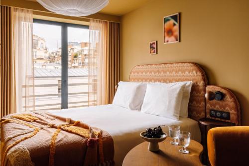 a hotel room with a bed and a window at Le Jardin de Verre by Locke in Paris