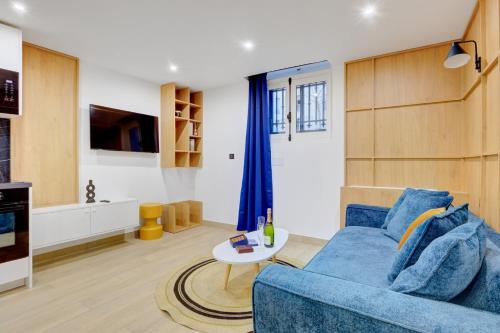 un salon avec un canapé bleu et une table dans l'établissement Bluestay 286 - Cozy appartement à Paris, à Paris
