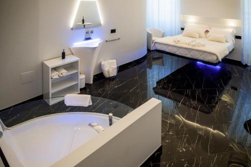 a bathroom with a tub and a bed in a room at Inferno e Paradiso in Gradara