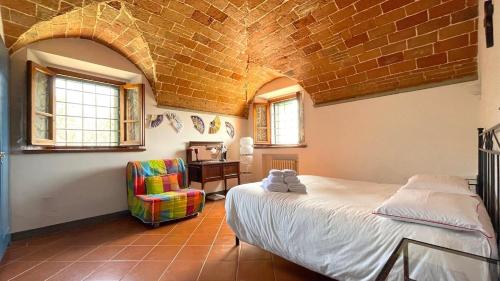 sypialnia z łóżkiem i krzesłem w obiekcie Brucina - Private holiday apartment with shared pool w mieście Montelupo Fiorentino