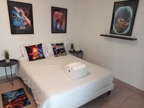 a bedroom with a white bed with a box on it at C301 Appartement Proche DisneyLand Paris in Montévrain