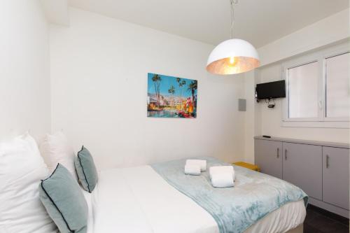 une chambre avec un grand lit blanc et une lampe dans l'établissement Le Grain d'Or YourHostHelper, à Cannes