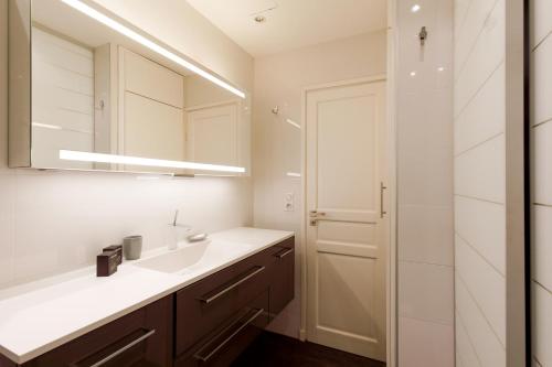 une salle de bain avec un lavabo et un miroir dans l'établissement Le Grain d'Or YourHostHelper, à Cannes