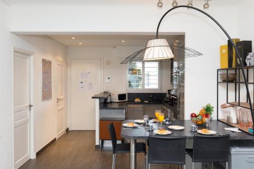 une cuisine avec une table avec des chaises et une salle à manger dans l'établissement Le Grain d'Or YourHostHelper, à Cannes