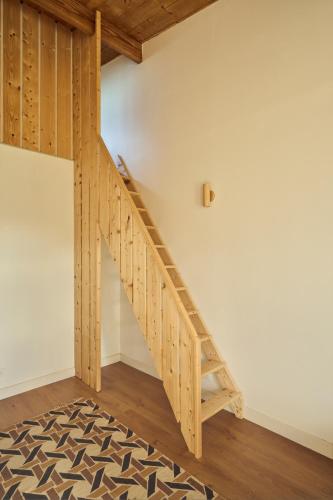 a wooden staircase in a room with a white wall at Maison moderne, ambiance californienne, proche mer in Plouescat
