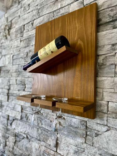 a bottle of wine on a wooden shelf on a wall at Apartment Centrum - Free private parking in Novi Sad