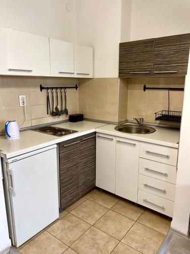 a kitchen with white cabinets and a sink at Apartment Centrum - Free private parking in Novi Sad