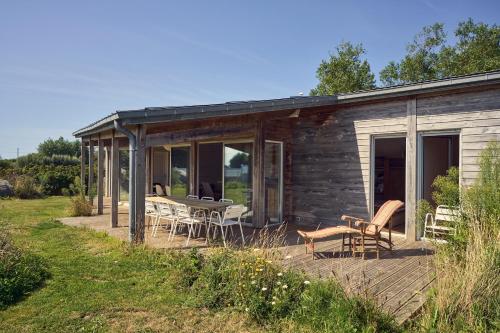 a log cabin with a table and chairs on a deck at Maison moderne, ambiance californienne, proche mer in Plouescat