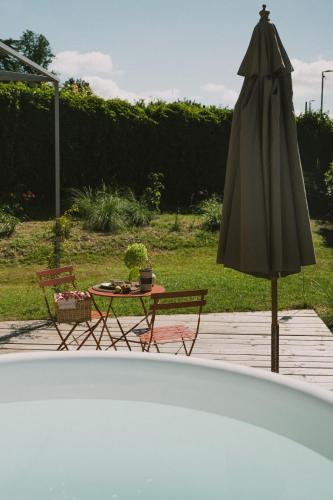 a patio with a table and an umbrella at Casa Kiko Pecetto in Pecetto