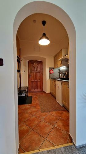 a kitchen with an archway in the middle of a room at Apartmány Fany in Zlaté Hory
