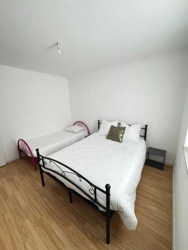 - une chambre blanche avec un lit et un canapé dans l'établissement Logement moderne au cœur de l'Alsace, à Niederbronn