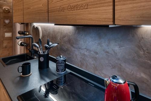 a kitchen with a sink and a red tea kettle at La Certosa in Chiusa di Pesio