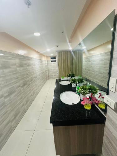 a bathroom with three sinks and a black counter at Cozy Mines View Apartment in Baguio