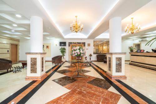 a lobby of a hotel with columns and a table at Hotel Plaza Mayor in Santo André