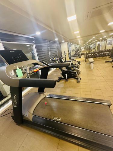 a gym with a row of treadmills and ellipticals at Cozy Mines View Apartment in Baguio