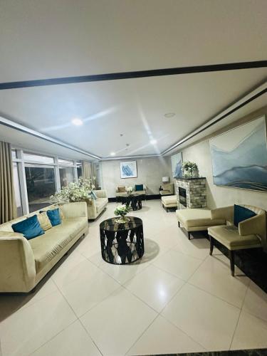 a large living room with couches and a table at Cozy Mines View Apartment in Baguio