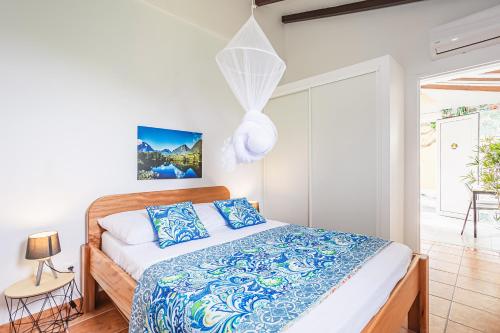 a bedroom with a bed with blue and white sheets at Gîte Dalina in Saint-François