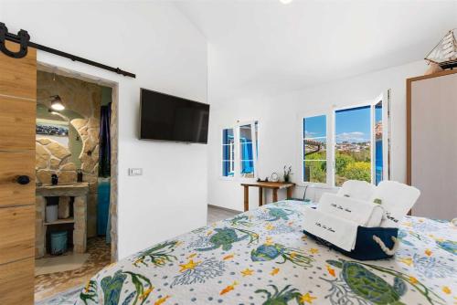 a bedroom with a bed and a tv and windows at Villa Lea Lana Vinodol by aneo travel in Novi Vinodolski
