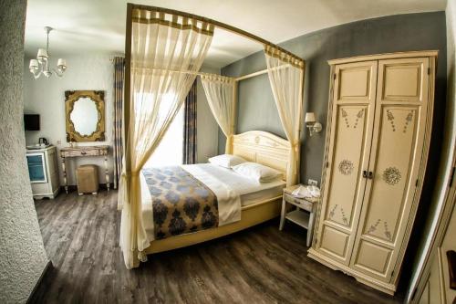 a bedroom with a canopy bed and a mirror at Villa Fanti in Cesme