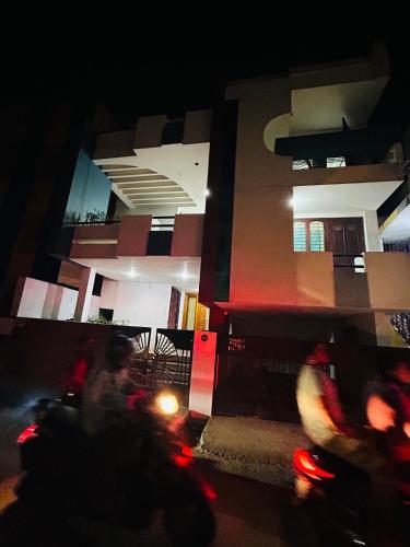 a person riding a motorcycle in front of a building at night at Stay Confo Villa in Puducherry