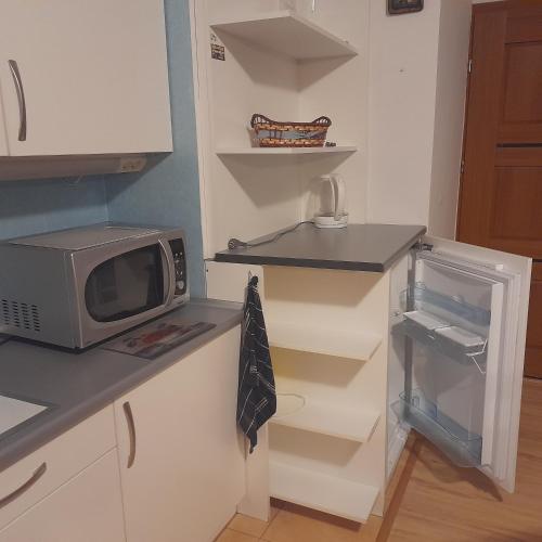 a kitchen with a microwave and a refrigerator at Willa Gracja in Wisła