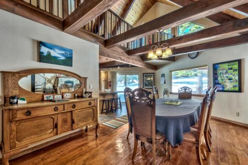 a dining room with a table and chairs and wooden ceilings at Tall Pines in South Lake Tahoe