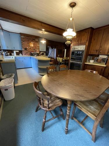 a kitchen with a large wooden table and chairs at SUNSET HAVEN LIMIT 8 cottage in Gray