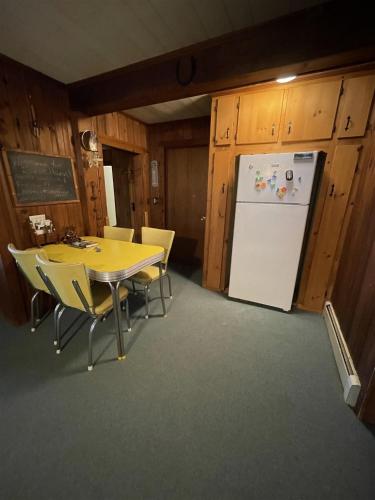 a dining room with a table and a refrigerator at SUNSET HAVEN LIMIT 8 cottage in Gray