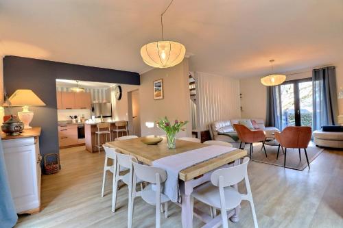 une cuisine et une salle à manger avec une table et des chaises dans l'établissement Maison Saint LU, à Saint-Lunaire