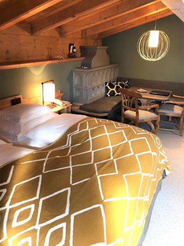 a bedroom with a large bed and a table at Hotel Berghof in Lech am Arlberg
