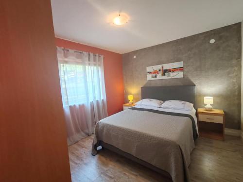 sypialnia z dużym łóżkiem i oknem w obiekcie Apartments Bosana XIV w Biogradzie na Moru