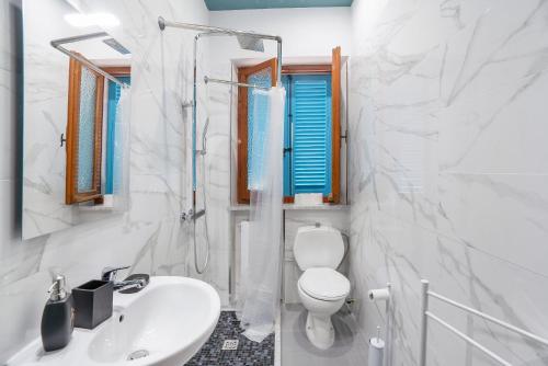 a white bathroom with a toilet and a sink at Casa degli Zii appartamento Letizia in Luni