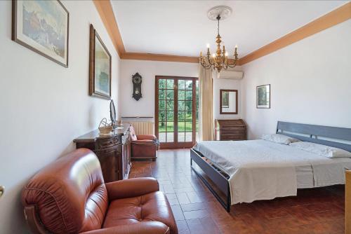 a bedroom with a bed and a couch and a chair at Casa degli Zii appartamento Letizia in Luni