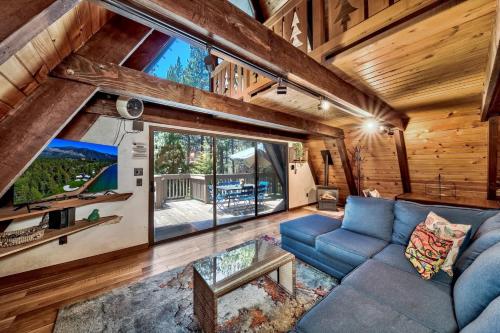 a living room with a blue couch and a large window at 3001R Reindeer A Frame Cabin in South Lake Tahoe