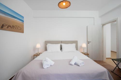 a bedroom with a white bed with two white towels at Villa Jessy 150m² with Full Privacy in Parikia