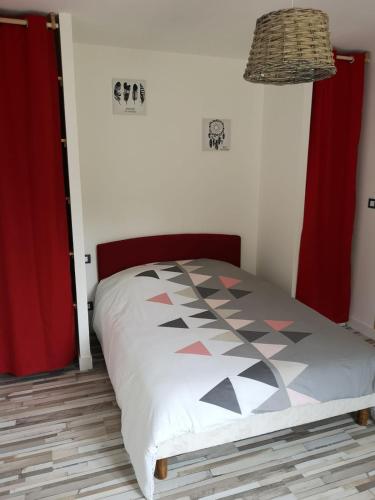 - une chambre avec un lit et des rideaux rouges dans l'établissement La petite maritaise du petit bois, à Sainte-Marie de Ré